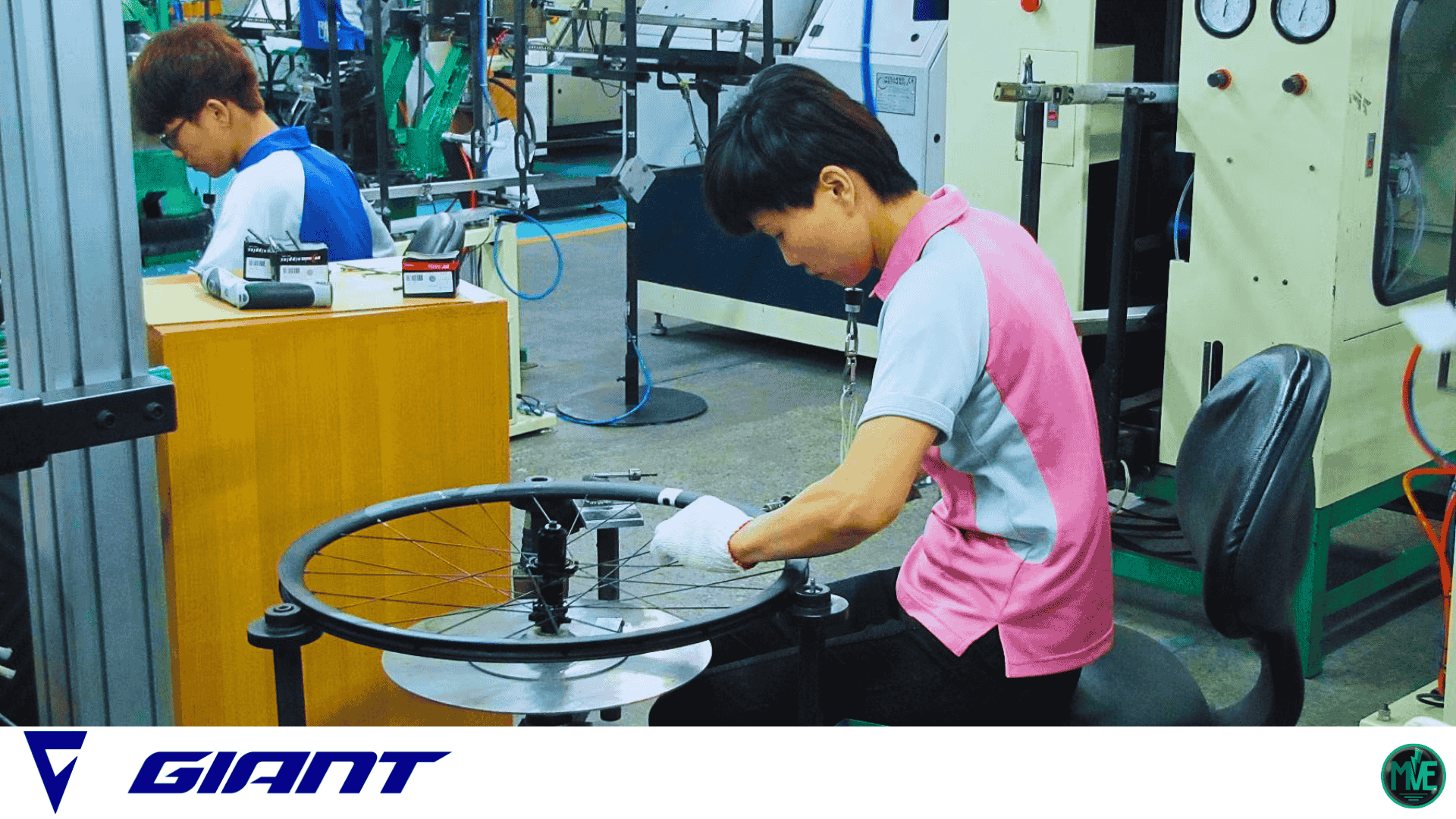 Technicien assemble et contrôle une roue de vélo sur la chaîne de production Giant, poste de rayonnage en atelier.