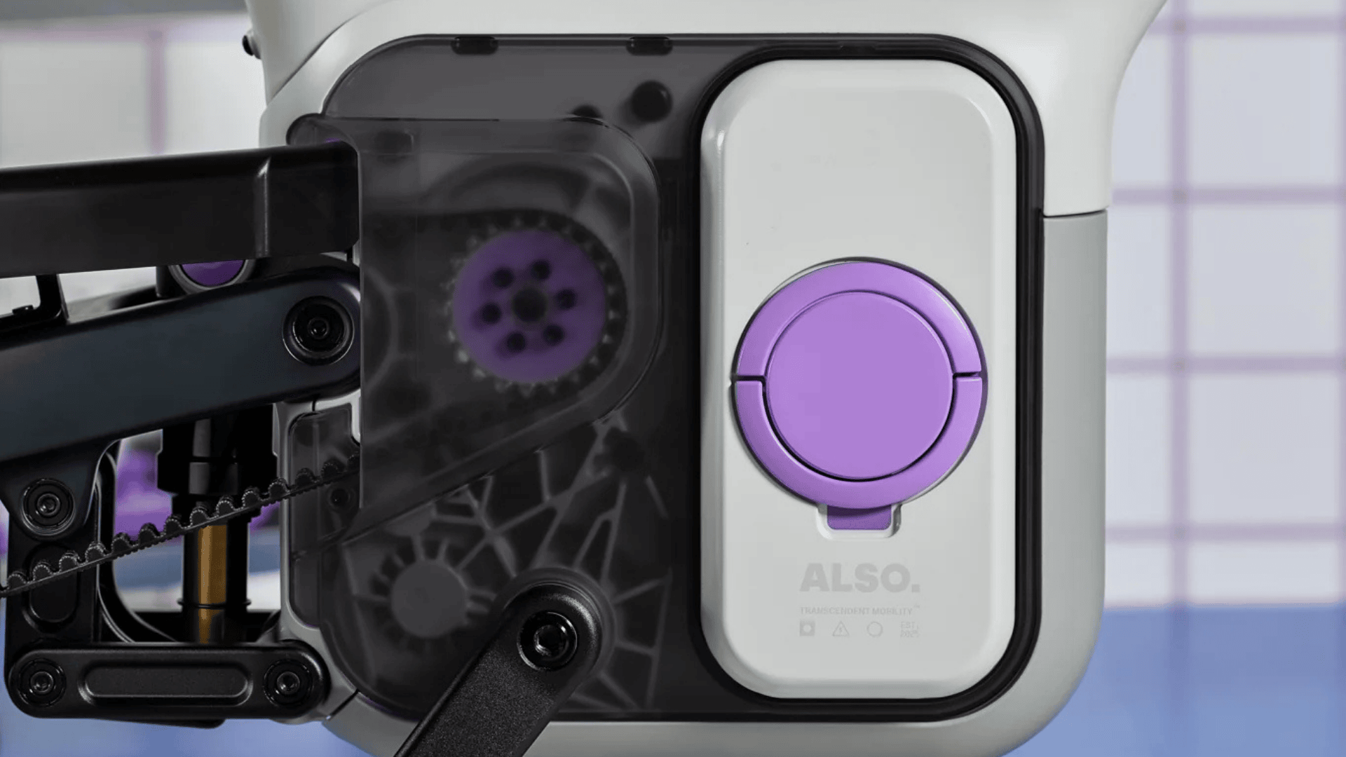 Gros plan du bloc moteur-batterie de l’Also TM-B de Rivian avec carter transparent et courroie.