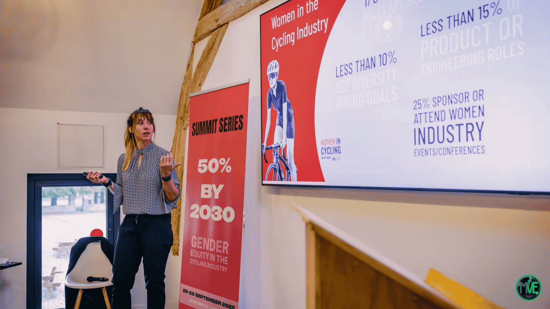 Intervenante présentant des statistiques sur la parité dans l’industrie du vélo lors d’un Summit Series ; à l’écran « Women in Cycling » et l’objectif « 50% by 2030 ».