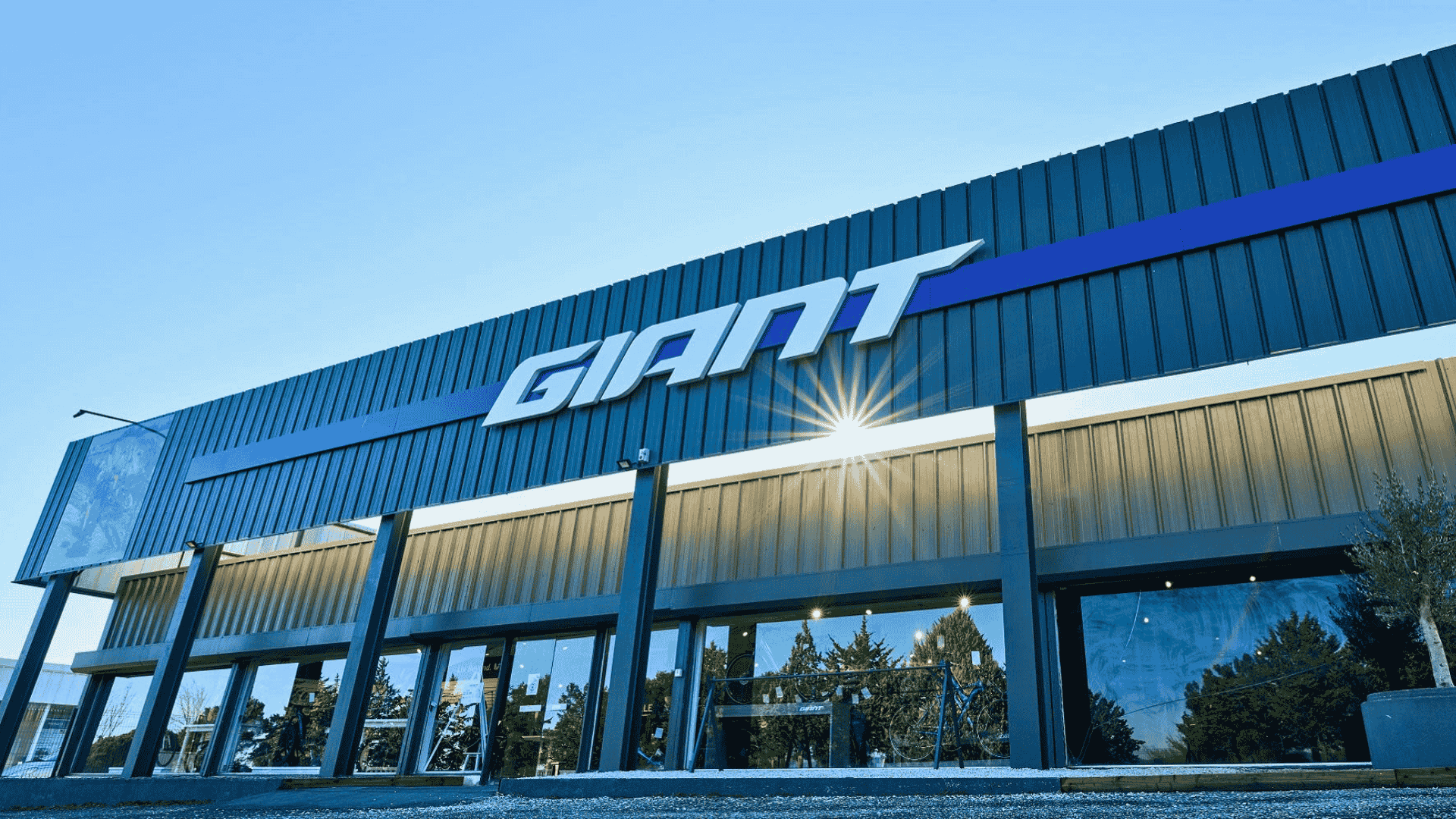 Façade d’un magasin Giant, ciel bleu et soleil rasant, illustrant l’initiative de la Taiwan Bicycle Association sur les droits de l’homme dans l’industrie vélo