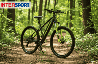 VTT électrique Nakamura E Summit EVO 26″ noir et jaune, posé sur un chemin forestier, avec fourche suspendue et freins à disque