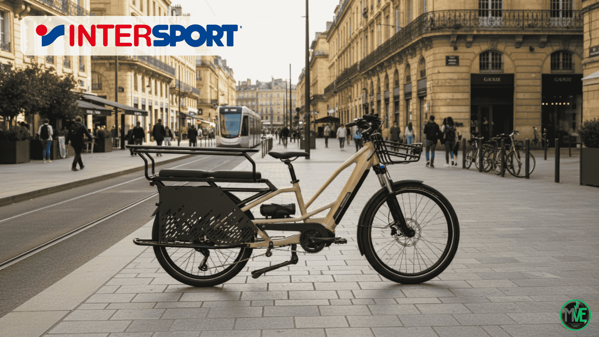 Vélo cargo électrique Nakamura Crossover Longtail en promotion chez Intersport, stationné en ville sur une piste cyclable